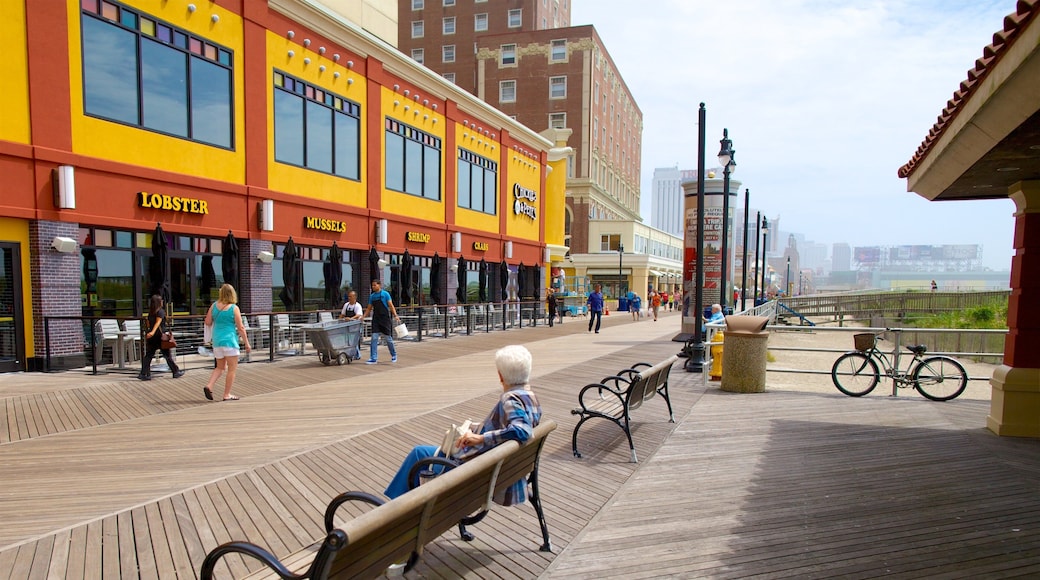 Atlantic City Boardwalk which includes a coastal town and street scenes as well as an individual femail