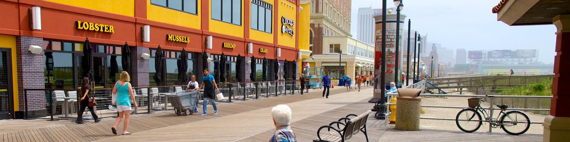 Atlantic City Boardwalk which includes a coastal town and street scenes as well as an individual femail
