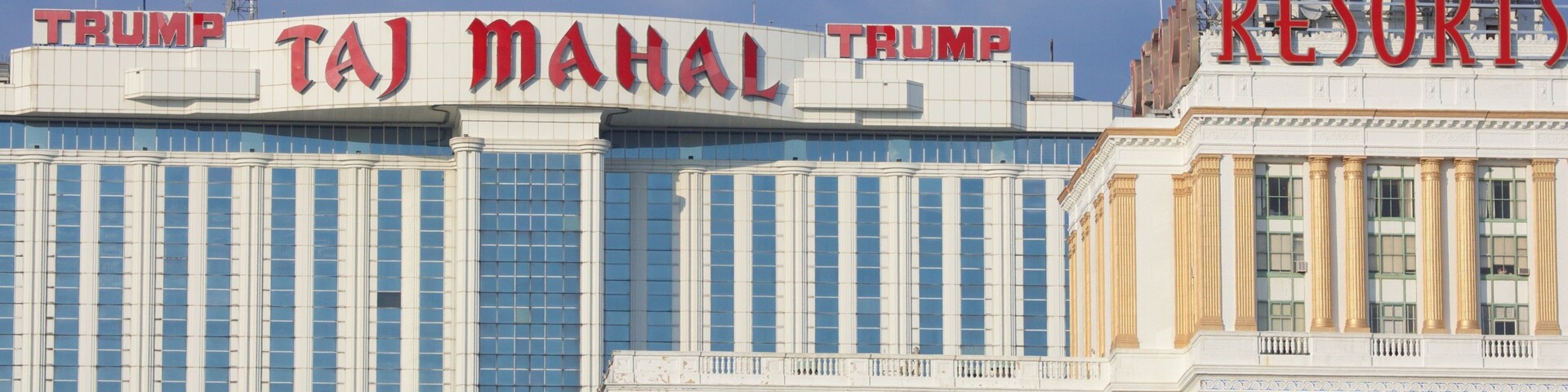 Un edificio con letreros que dicen 'TRUMP' y 'RESORTS', y otro edificio con letreros que dicen 'TAJ MAHAL'.
