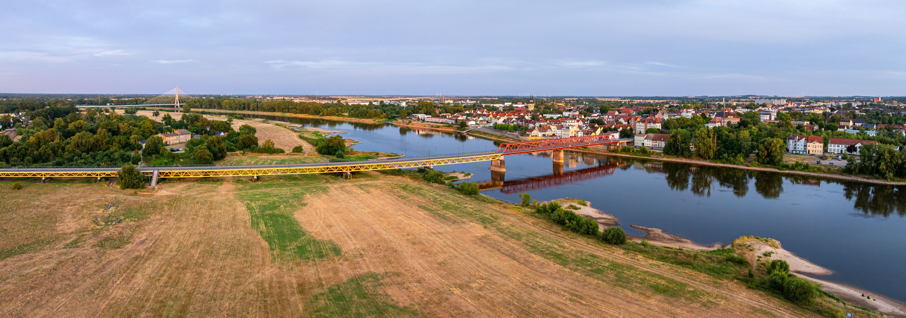 A river with bridges, a town, and a bridge with a unique design.