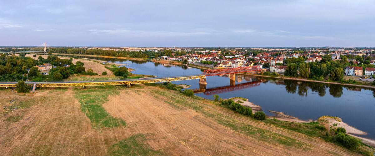 A river with bridges, a town, and a bridge with a unique design.