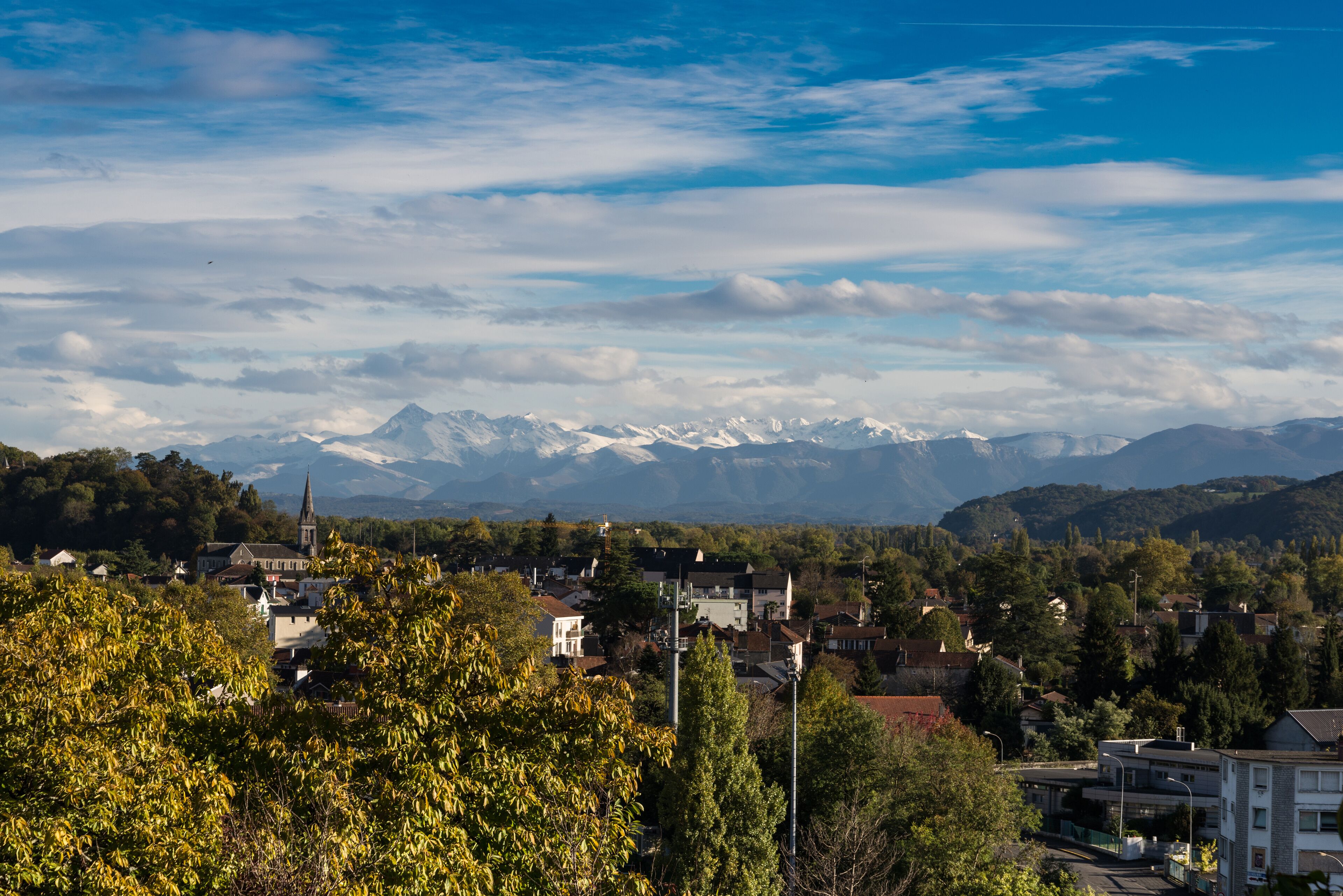 French town Pau against the winter Pyrenees mountains peaks