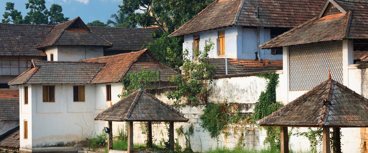 Traditional houses with tiled roofs and a calm water body in the foreground.