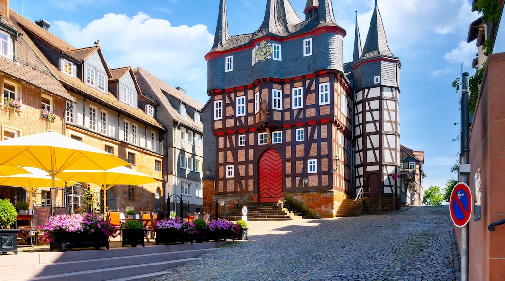 Ein historischer europäischer Stadtplatz mit Kopfsteinpflasterstraßen, traditionellen Fachwerkhäusern und einem markanten Glockenturm.