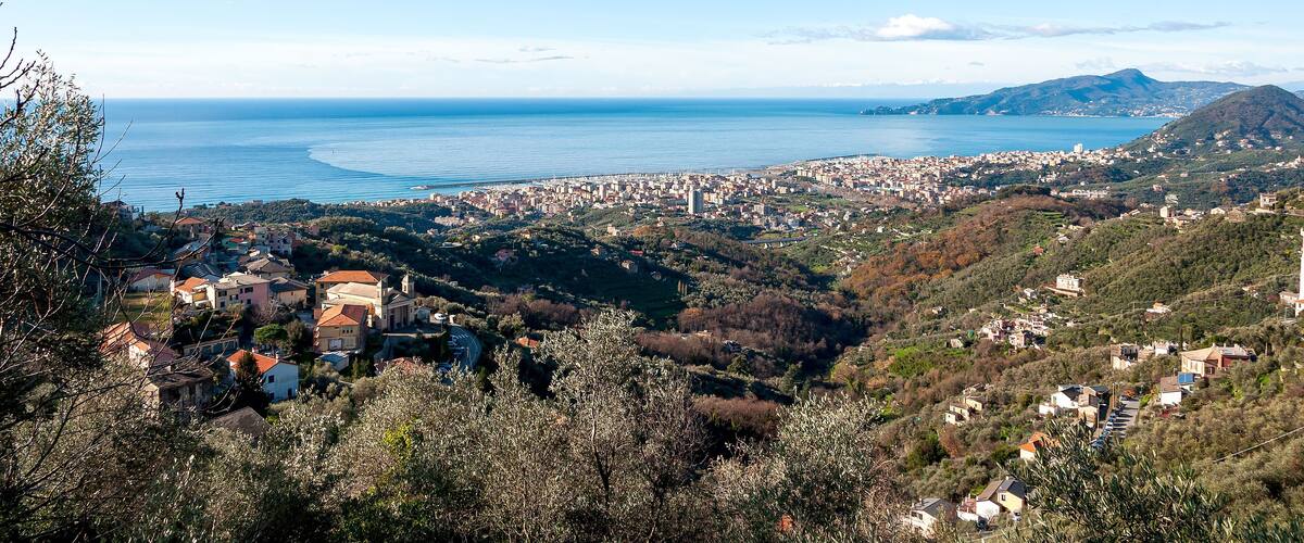 A coastal town with a view of the sea and hills.