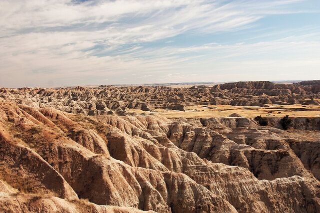 A vast, rugged landscape with eroded hills and valleys.