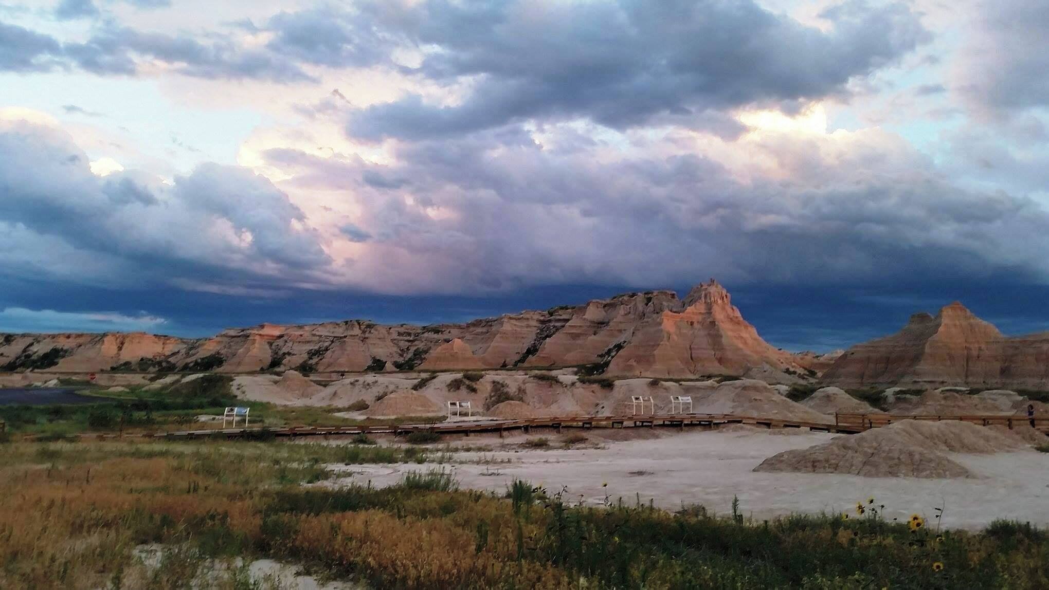 A rugged landscape with layered rock formations and a cloudy sky.
