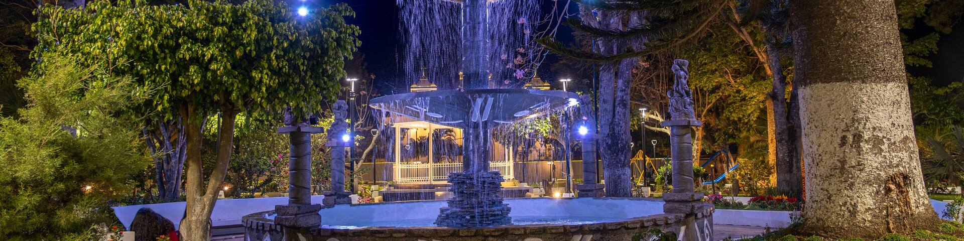 Lit up fountain at the main square of a small tourist town Concepcion De Ataco at Ruta de las Flores in El Salvador. Night shot, long exposure.