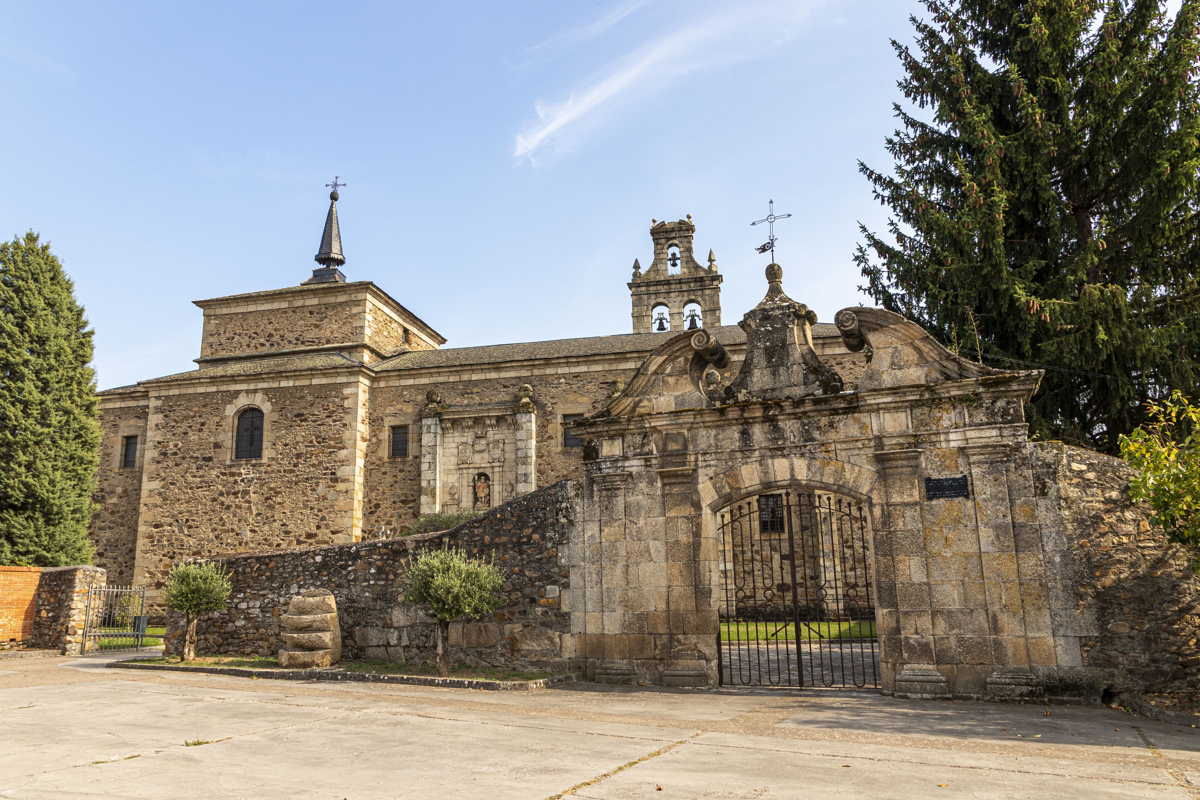 A historic stone building with a bell tower and a large arched entrance gate.