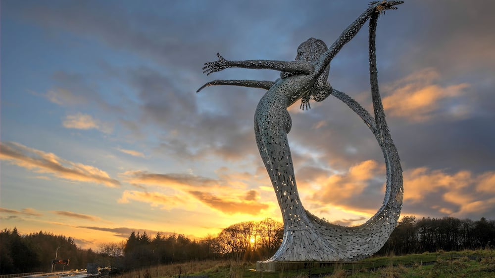 E46EJY Arria Sculpture by Andy Scott at sunrise