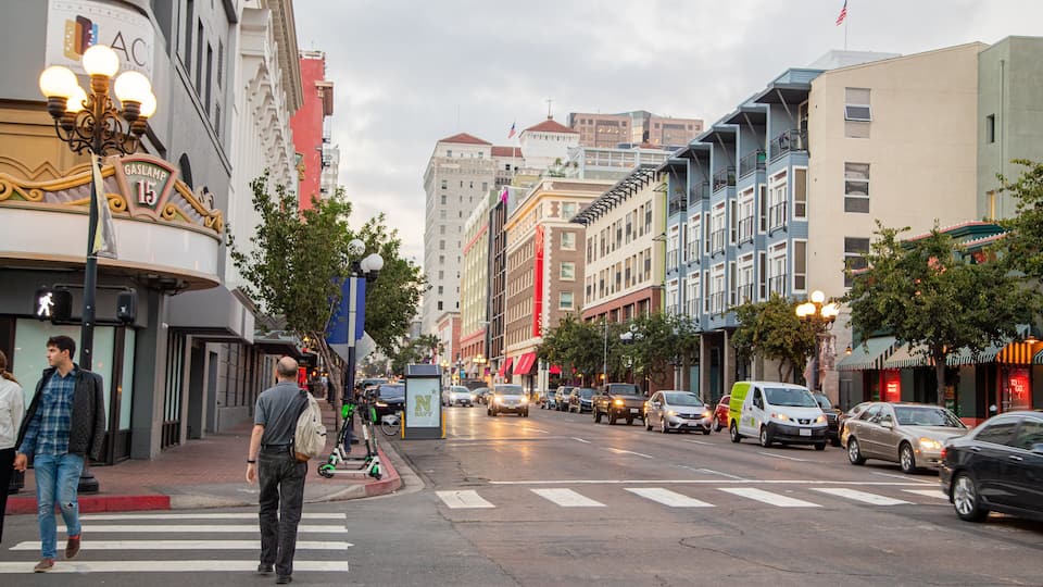 Une rue de la ville avec des immeubles, des voitures et un passage piéton.