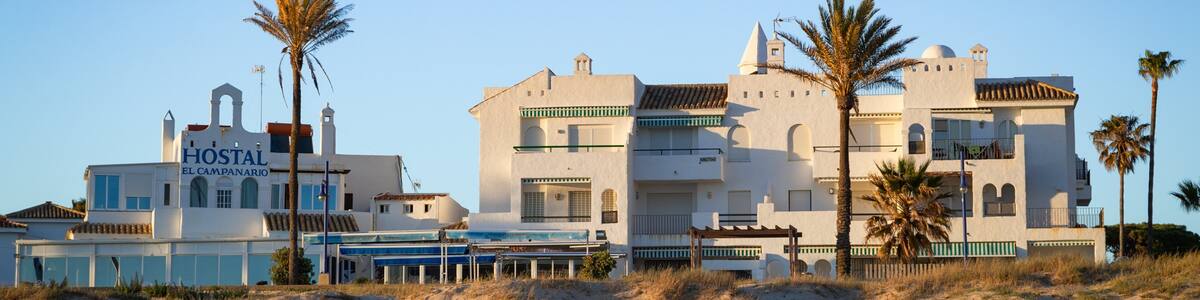 La Barrosa Beach featuring a coastal town, a sunset and a beach