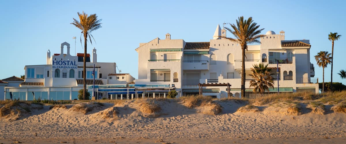 La Barrosa Beach featuring a coastal town, a sunset and a beach