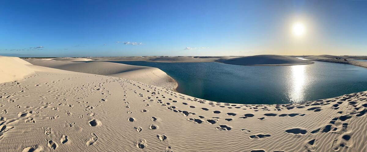 A desert landscape with sand dunes and a body of water.