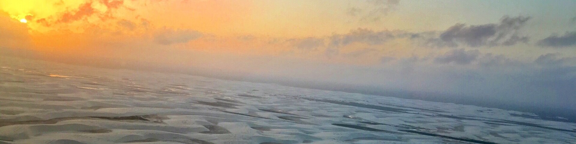Um glaciar com o pôr do sol ao fundo.