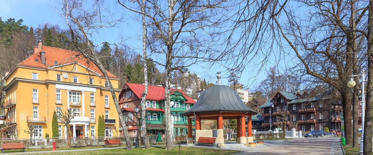 A park with colorful buildings, a gazebo, and a clear sky.
