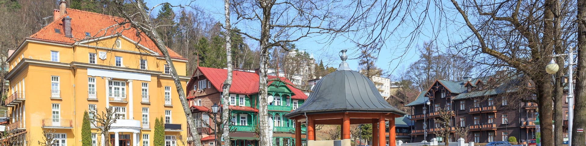 A park with colorful buildings, a gazebo, and a clear sky.