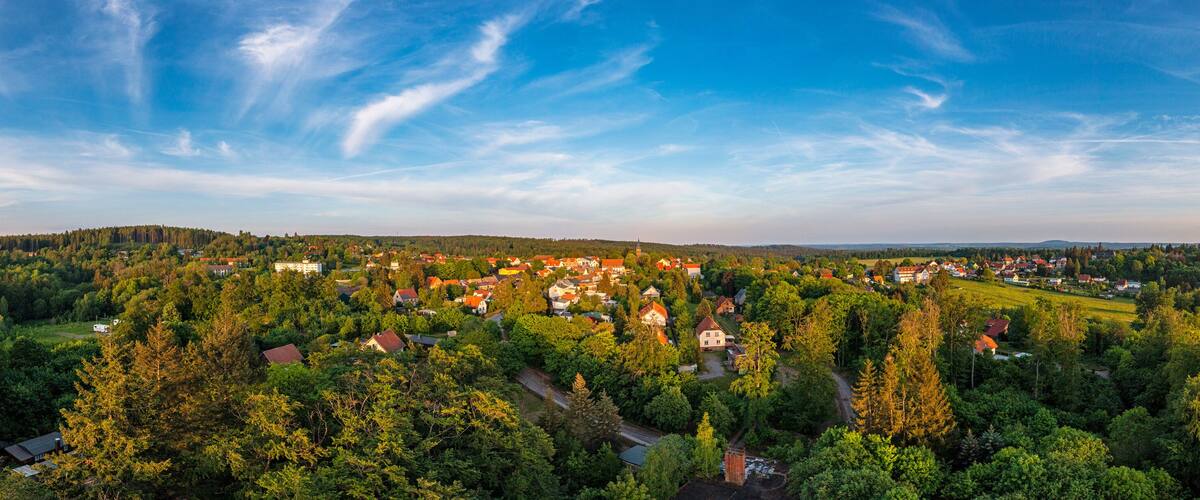 A town nestled in a forest with a clear sky.