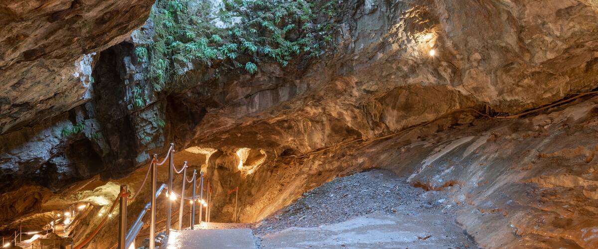 A cave with a wooden staircase leading to a higher level.