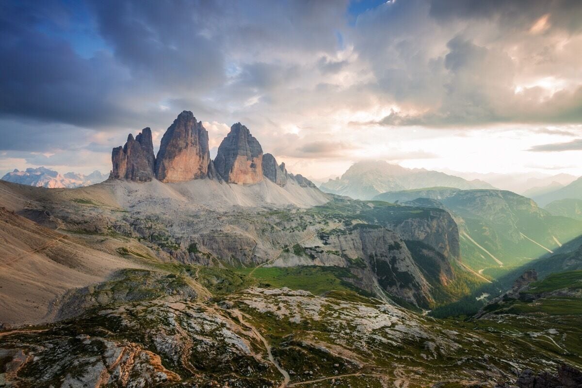 A mountainous landscape with prominent rock formations and a winding road.