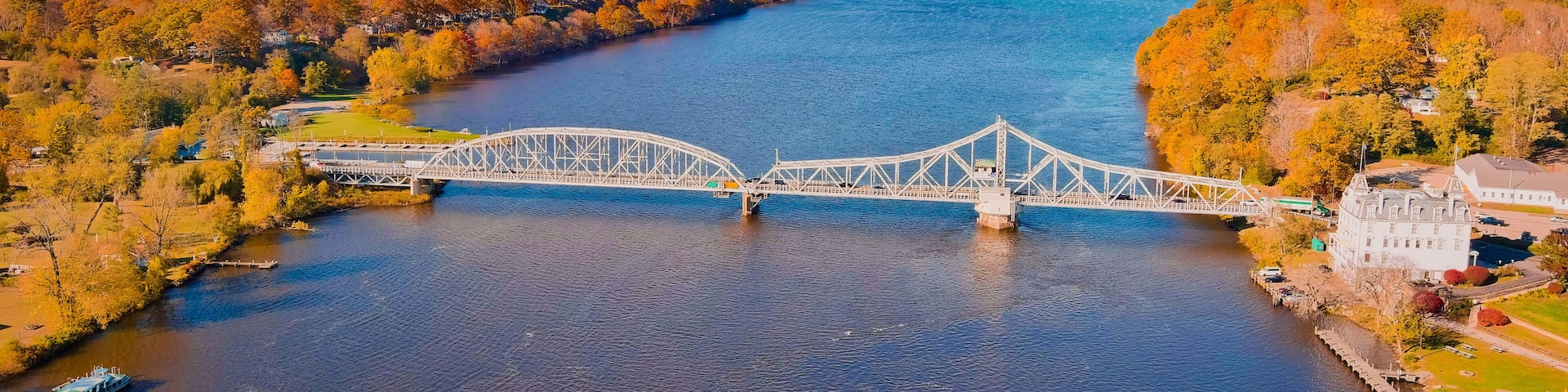 Autumn forest on the riverside, beautiful trees, blue river and bridge. Fall colors. View above. East haddam, Connecticut