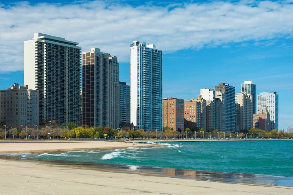 A coastal cityscape with high-rise buildings and a beach.