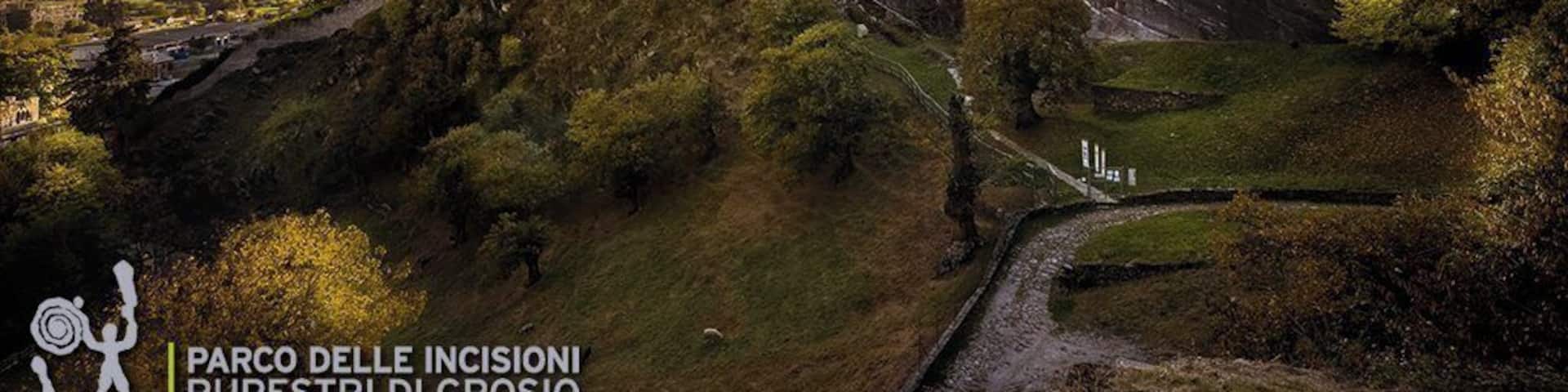 Guided tours at 10.30, 14.00 and 16.00!
The Rock Engraving Park is a unique combination of the archaeological, architectural, historical and even landscape patrimony of various ages of the Valtellina. The Park was founded in 1978 to conserve, study and develop the Cultural Heritage on the Castle Hill (Dosso dei Castelli). Next to the two castles, the Castello Vecchio (Old Castle) from the 10th-11th century and the Castello Nuovo (New Castle) from the 14th century, even a system of dry-stone terraces, how it is typically for the Valtellina, is surrounding the Castle Hill. But special and singular is the Rupe Magna, a large rock which contains more than 5.000 engraved figures from the 4th to the 1st millennium B.C.