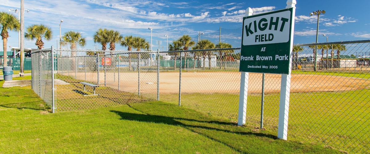 A baseball field with a sign reading "KIGHT FIELD AT Frank Brown Park Dedicated May 2005".