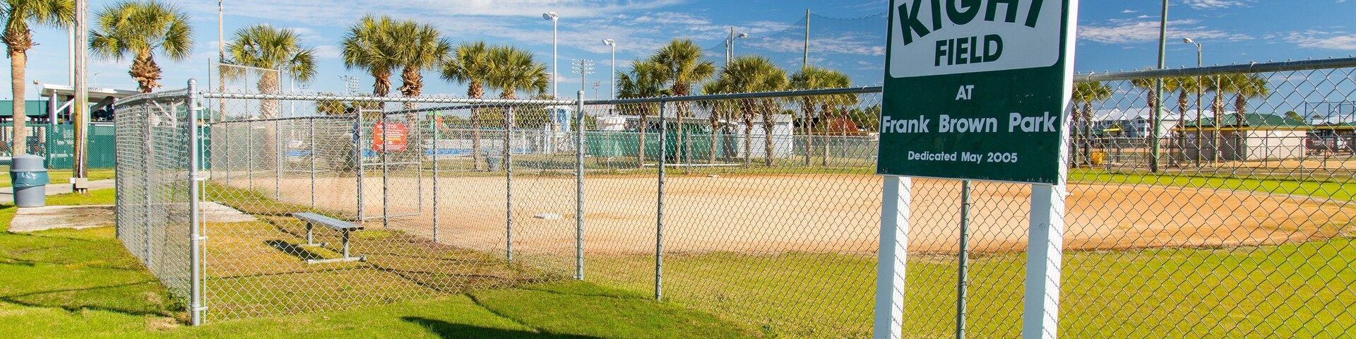 A baseball field with a sign reading "KIGHT FIELD AT Frank Brown Park Dedicated May 2005".