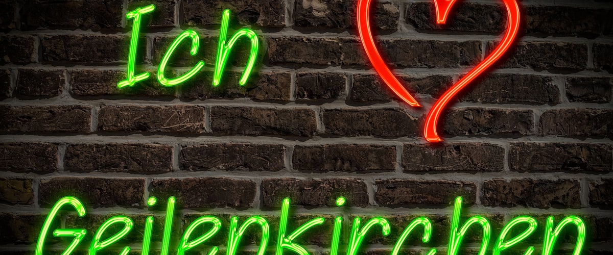 A neon sign on a brick wall with the text "Ich Geilenkirchen" and a red heart.