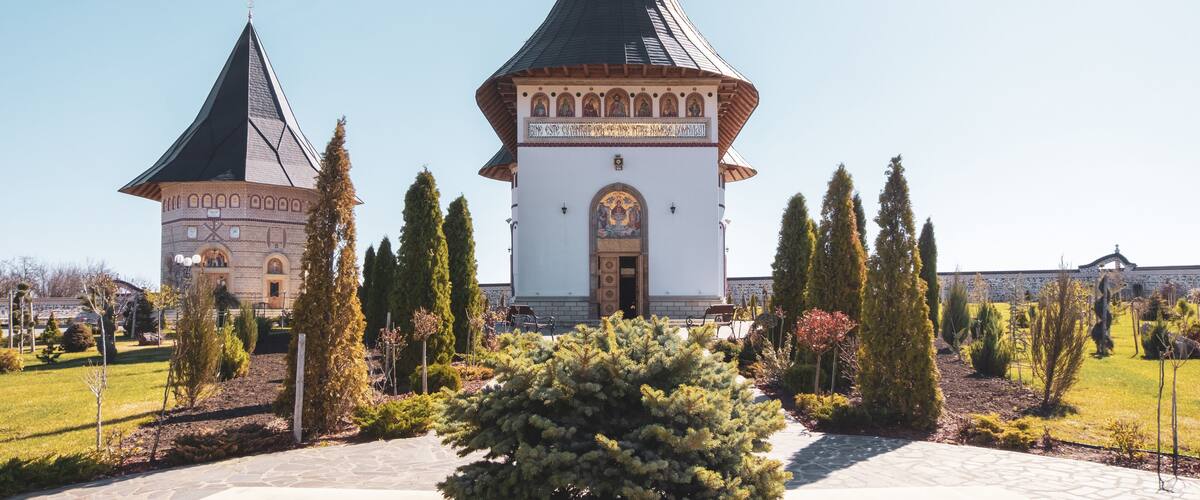 A church with two towers and a well-maintained garden.