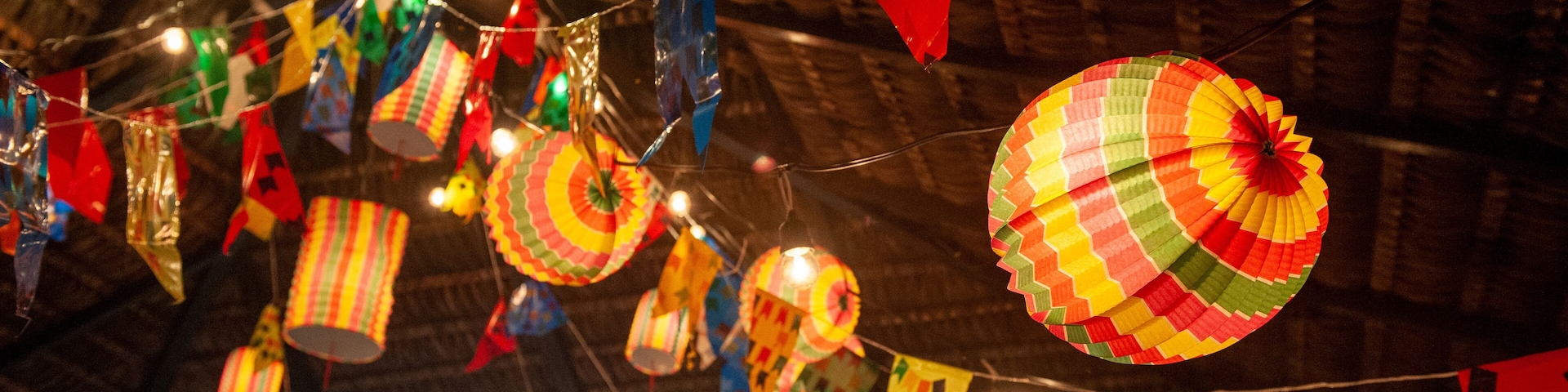 Traditional flags and lanterns of June festivities in northeastern Brazil. Background colorful.