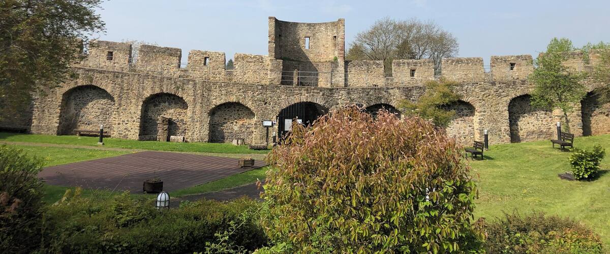 A historic stone castle with arched walkways and a tower.