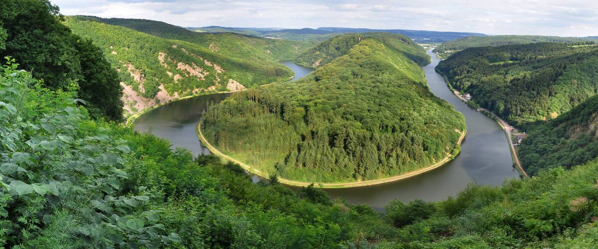 A river winding through a forested valley with steep hills on either side.