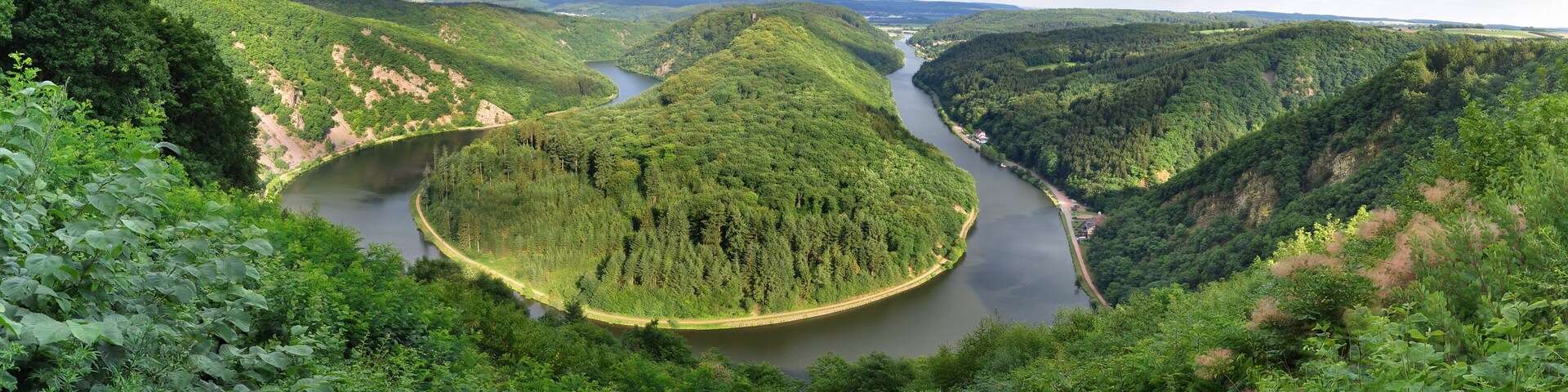A river winding through a forested valley with steep hills on either side.