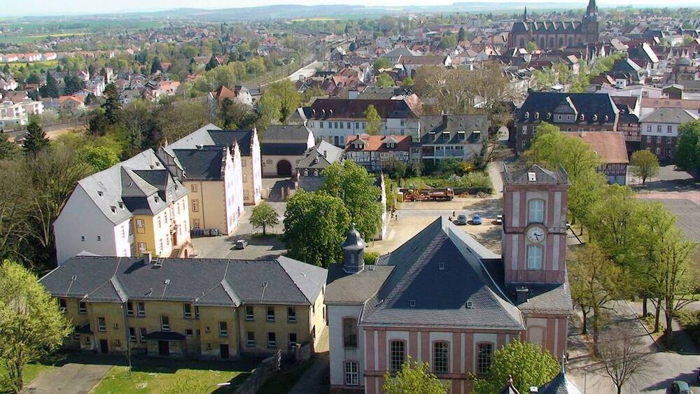 Eine Stadt mit historischen Gebäuden, einem markanten Glockenturm und einer Kirche mit einem hohen Turm.