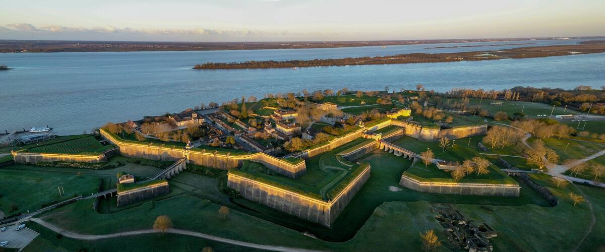 A fortified castle complex by a river.
