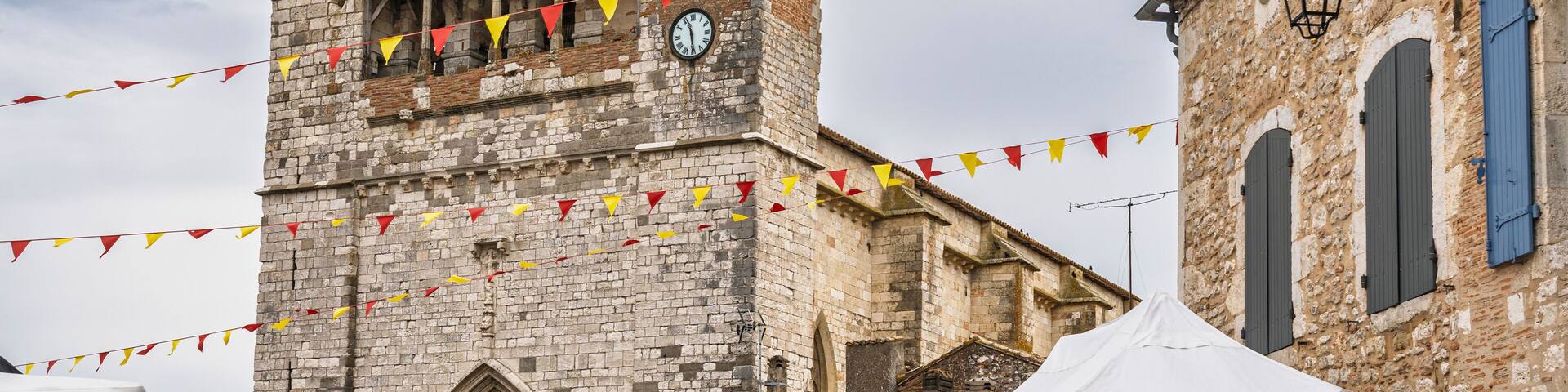 Landscape view of the facade of ancient Notre Dame church in medieval Villereal town, Lot-et-Garonne, France