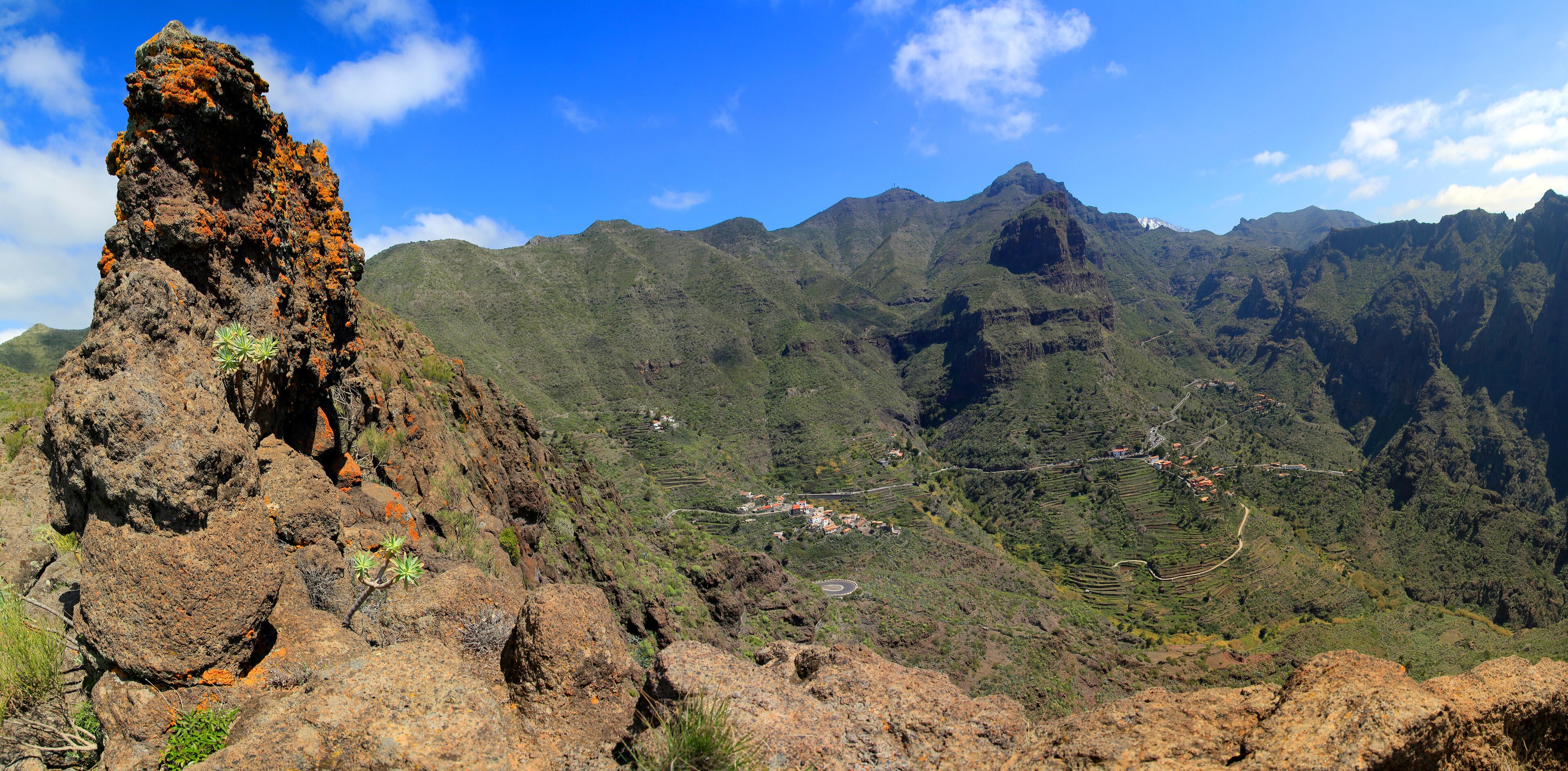 A volcanic rock formation with a village in the valley below.