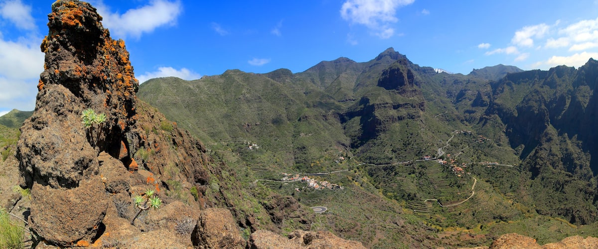 A volcanic rock formation with a village in the valley below.