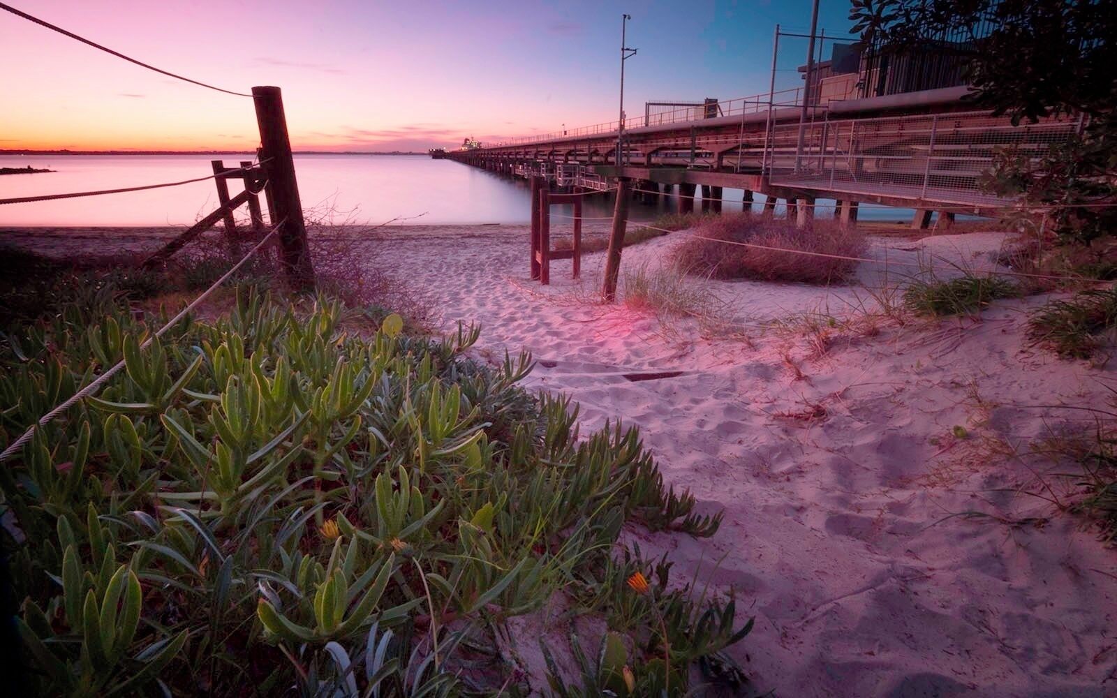 I recommend photographing this place during the summer. Also the sun sets are lengthy and in a good area.

The main attraction is the Caltex Jetty that unloads terrible oily stuff from the cargo ships. So you may get a large ship docked at the end of it. 

NOTE: Its a good 2hr drive from Sydney (inc traffic time), so allow enough time to get here