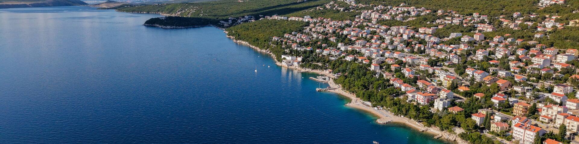 Aerial drone view of Crikvenica and Dramalj with turquoise Adriatic Sea, green-blue waters, beaches, and the island of Krk in the distance. Taken on 27.09.2025 in Dramalj, Croatia.