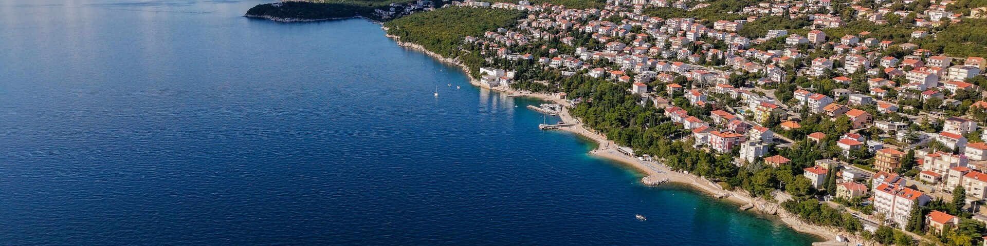 Aerial drone view of Crikvenica and Dramalj with turquoise Adriatic Sea, green-blue waters, beaches, and the island of Krk in the distance. Taken on 27.09.2025 in Dramalj, Croatia.
