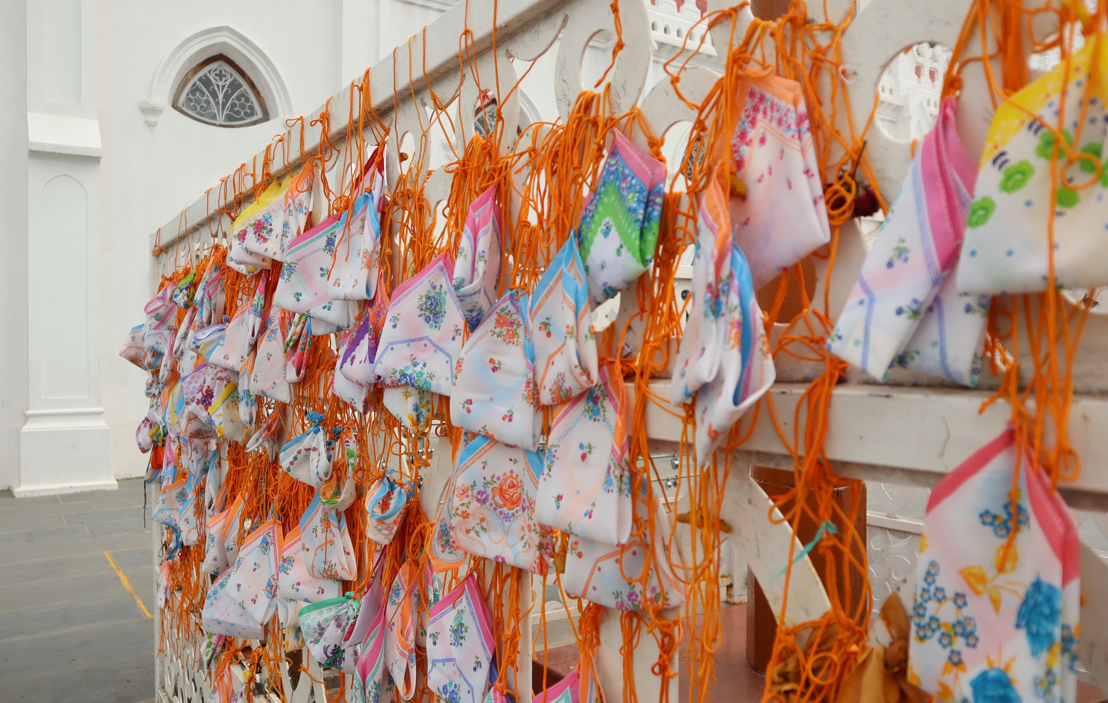 A wall adorned with colorful bags hanging in a row.