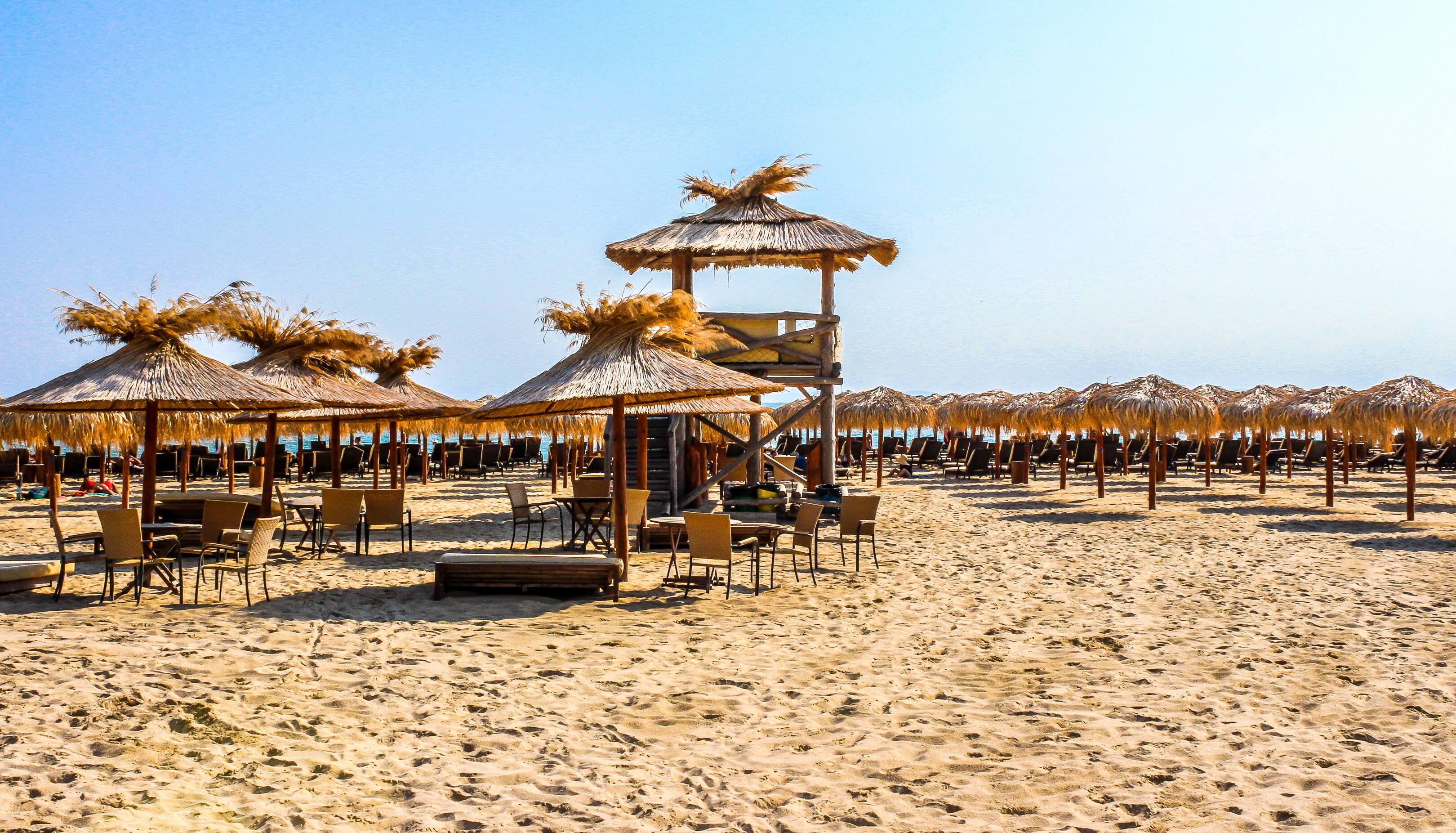 Beach with straw umbrellas.