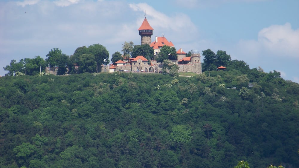 Most, Most District, Ústí nad Labem Region, Czech Republic. Hněvín hill and castle, seen from nearby the city theatre.