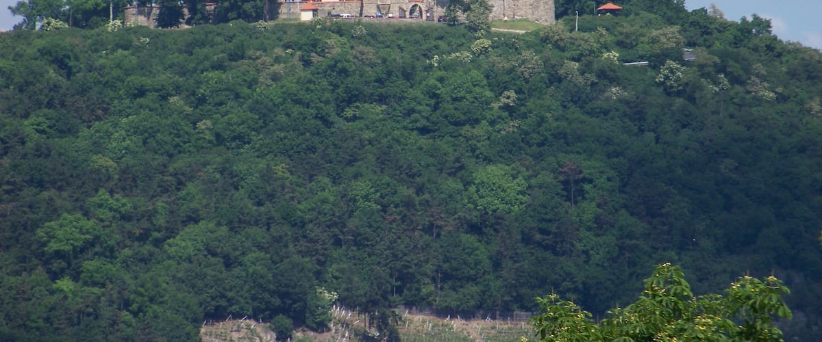 Most, Most District, Ústí nad Labem Region, Czech Republic. Hněvín hill and castle, seen from nearby the city theatre.