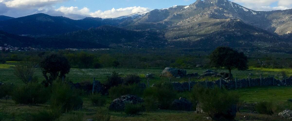 A mountain range with a clear sky and scattered clouds.