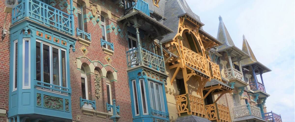 A row of colorful, ornate buildings with intricate architectural details and vibrant blue and yellow accents.