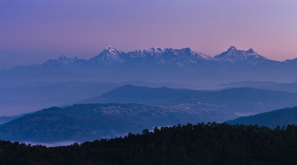 Aerial view of Garwal Himalayas at dawn with snow-capped peaks and serene valley, Mukteshwar, Uttarakhand, India.